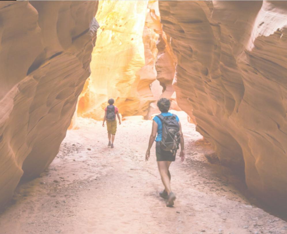 Two women hiking in a slot canyon.